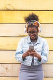 Afro- amerikansk tonårs- flicka som använder mobiltelefondet fria fotografering för bildbyråer Afro- amerikansk tonårs- flicka som använder mobiltelefondet fria fotografering för bildbyråer