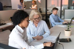 Afroamerikanergesch?ftsfrau mit dem reifen Angestellten, der zusammenarbeitet stockfotografie Afroamerikanergesch?ftsfrau mit dem reifen Angestellten, der zusammenarbeitet stockfotografie