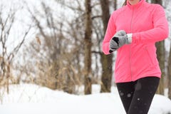 Agent die smartwatch jogging gebruikt die in de winter loopt stock afbeeldingen Agent die smartwatch jogging gebruikt die in de winter loopt stock afbeeldingen