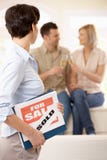 Agente de la propiedad inmobiliaria que mira de celebración de pares imagenes de archivo Agente de la propiedad inmobiliaria que mira de celebración de pares imagenes de archivo