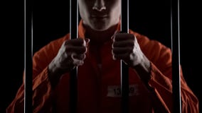 Aggressive inmate holding prison bars, unfairly judged, court sentence appeal stock photos Aggressive inmate holding prison bars, unfairly judged, court sentence appeal stock photos