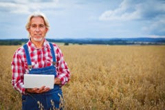 Agriculteur Standing In un gisement de céréale photos stock Agriculteur Standing In un gisement de céréale photos stock