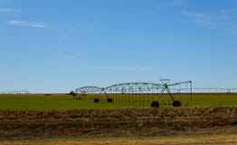 Agricultural irrigation system watering field on sunny day stock photos Agricultural irrigation system watering field on sunny day stock photos