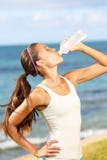Agua potable de la mujer de la aptitud después del funcionamiento de la playa imagen de archivo libre de regalías Agua potable de la mujer de la aptitud después del funcionamiento de la playa imagen de archivo libre de regalías