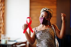 AIDS awareness. Stylish african american woman with dreadlocks afro hair, wear face protect  mask and headdress leopard scarf,