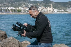 Aire libre de la grabación del cameraman mientras que registra un clip de vídeo musical fotografía de archivo libre de regalías Aire libre de la grabación del cameraman mientras que registra un clip de vídeo musical fotografía de archivo libre de regalías