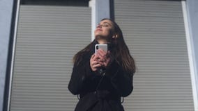 Aire libre derecho femenino joven que concierta la cita en el teléfono, aire fresco que huele metrajes Aire libre derecho femenino joven que concierta la cita en el teléfono, aire fresco que huele metrajes