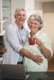Ajouter supérieurs de sourire à l'ordinateur portable se tenant prêt de tasse de café à la maison image stock Ajouter supérieurs de sourire à l'ordinateur portable se tenant prêt de tasse de café à la maison image stock