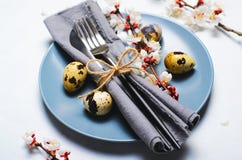 Ajuste de la tabla de Pascua con los huevos y las ramas de codornices en el flor, fondo de los d?as de fiesta de la primavera imagen de archivo libre de regalías Ajuste de la tabla de Pascua con los huevos y las ramas de codornices en el flor, fondo de los d?as de fiesta de la primavera imagen de archivo libre de regalías
