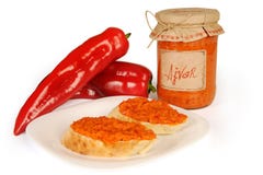 Ajvar - prato delicioso de pimentas vermelhas e verdes, cebolas, alho, beringela Ajvar no frasco O molho espalhou em duas fatias foto de stock royalty free Ajvar - prato delicioso de pimentas vermelhas e verdes, cebolas, alho, beringela Ajvar no frasco O molho espalhou em duas fatias foto de stock royalty free