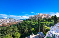 Akropol med Parthenon Sikt till och med en ram med gröna växter, träd, forntida marmor och cityscape, Aten royaltyfria bilder Akropol med Parthenon Sikt till och med en ram med gröna växter, träd, forntida marmor och cityscape, Aten royaltyfria bilder
