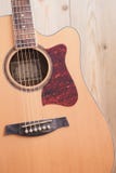 Akustisk gitarr som vilar mot en träbakgrund arkivfoto Akustisk gitarr som vilar mot en träbakgrund arkivfoto
