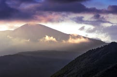 Alba drammatica nelle montagne con il cielo nuvoloso e Misty Forest, montagne di Altai, il Kazakistan orientale Fantasyland, ora immagine stock Alba drammatica nelle montagne con il cielo nuvoloso e Misty Forest, montagne di Altai, il Kazakistan orientale Fantasyland, ora immagine stock
