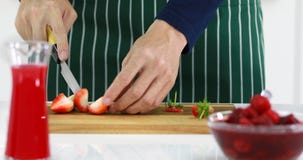 Alguien que usa el cuchillo a cortar las fresas almacen de video Alguien que usa el cuchillo a cortar las fresas almacen de video