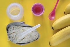 Aliment pour bébé sur une nutrition jaune de fond, de biberon et de bananes photos stock Aliment pour bébé sur une nutrition jaune de fond, de biberon et de bananes photos stock