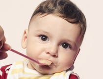 Alimenti per bambini dell'infante di alimentazione manuale della madre Fotografia Stock Alimenti per bambini dell'infante di alimentazione manuale della madre Fotografia Stock