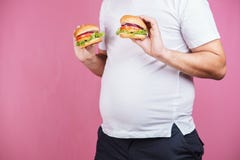 Aliments de préparation rapide et gain de poids gros homme avec des hamburgers photo libre de droits Aliments de préparation rapide et gain de poids gros homme avec des hamburgers photo libre de droits