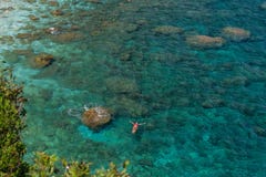 Alleinstehende Frau legt auf das schöne aquamarine haarscharfe Wasser im Entspannung, Draufsicht von der Höhe stockbilder Alleinstehende Frau legt auf das schöne aquamarine haarscharfe Wasser im Entspannung, Draufsicht von der Höhe stockbilder