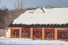 Allgemeine Dorfgaragen oder -hallen im Winter an einem sonnigen Tag Schnee auf dem Dach wird Eingänge nummeriert lizenzfreies stockbild Allgemeine Dorfgaragen oder -hallen im Winter an einem sonnigen Tag Schnee auf dem Dach wird Eingänge nummeriert lizenzfreies stockbild