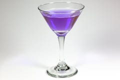 Allhelgonaafton inspirerad lilafärgcoctail i ett klart glass sammanträde på en vit tabell som väntar för att tyckas om royaltyfri foto Allhelgonaafton inspirerad lilafärgcoctail i ett klart glass sammanträde på en vit tabell som väntar för att tyckas om royaltyfri foto