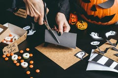 Allhelgonaaftonförberedelse Händer som gör halloween garnering genom att använda hantverket för att skyla över brister royaltyfri fotografi Allhelgonaaftonförberedelse Händer som gör halloween garnering genom att använda hantverket för att skyla över brister royaltyfri fotografi