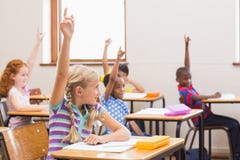 Allievi che sollevano le loro mani durante la classe Fotografia Stock