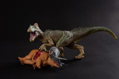 Allosaurus with a triceratops body nearby on dark stock photography Allosaurus with a triceratops body nearby on dark stock photography