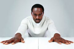 Allvarligt afrikanskt mansammanträde på tabellen arkivbilder Allvarligt afrikanskt mansammanträde på tabellen arkivbilder