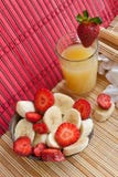Almoço do verão: corte bananas, morangos e suco fotografia de stock Almoço do verão: corte bananas, morangos e suco fotografia de stock