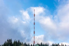 Alta torre misma de la transmisión delante del cielo azul nublado fotografía de archivo libre de regalías Alta torre misma de la transmisión delante del cielo azul nublado fotografía de archivo libre de regalías