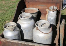alte Aluminiummilchdosen zum Transport der frischen Milch in einem hölzernen c lizenzfreies stockbild alte Aluminiummilchdosen zum Transport der frischen Milch in einem hölzernen c lizenzfreies stockbild