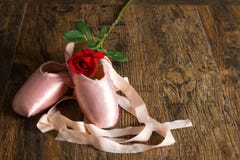 Alte benutzte Ballettpantoffel, die auf Boden mit Rosafarbenem und dem Blumenblatt liegen Stockfotos Alte benutzte Ballettpantoffel, die auf Boden mit Rosafarbenem und dem Blumenblatt liegen Stockfotos