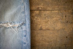 Alte Blue Jeans mit heftiger Beschaffenheit auf Holz Lizenzfreies Stockbild