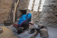 Alte Damenbratkaffeebohnen von Oman in einem alten traditionellen kitch stockfoto Alte Damenbratkaffeebohnen von Oman in einem alten traditionellen kitch stockfoto