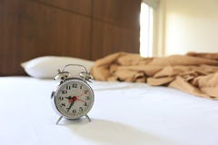 Alter Wecker auf Bett im Schlafzimmer stockbild Alter Wecker auf Bett im Schlafzimmer stockbild