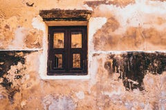 Altes weißes hölzernes Fenster des Weinlesetones auf dem rustikalen gelben Betonmauerfassadenhintergrund stockfoto Altes weißes hölzernes Fenster des Weinlesetones auf dem rustikalen gelben Betonmauerfassadenhintergrund stockfoto