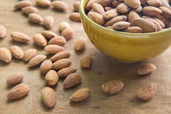 Amandes dans la cuvette sur le fond en bois, foyer sur des amandes dans la cuvette photo libre de droits Amandes dans la cuvette sur le fond en bois, foyer sur des amandes dans la cuvette photo libre de droits