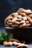 Amandes dans une cuvette, fond noir, foyer sélectif photos stock Amandes dans une cuvette, fond noir, foyer sélectif photos stock