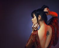 Amazing dark-haired tender graceful princess of Japan, a young girl in a light red dress with an open back and a royalty free stock images Amazing dark-haired tender graceful princess of Japan, a young girl in a light red dress with an open back and a royalty free stock images