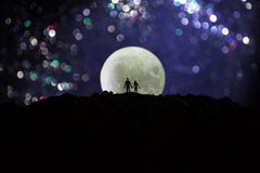 Amazing love scene. Silhouettes of young romantic couple standing under the moon light stock images Amazing love scene. Silhouettes of young romantic couple standing under the moon light stock images