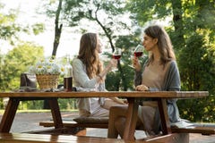 Amazing young two women sitting outdoors in park drinking wine royalty free stock photo Amazing young two women sitting outdoors in park drinking wine royalty free stock photo