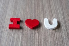 AME la palabra de las letras de madera del alfabeto con la mano de la mujer que lleva a cabo forma roja del corazón en fondo de l imagen de archivo libre de regalías AME la palabra de las letras de madera del alfabeto con la mano de la mujer que lleva a cabo forma roja del corazón en fondo de l imagen de archivo libre de regalías