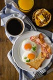 American breakfast with sunny side up eggs, bacon, toast, pancakes, coffee and juice Royalty Free Stock Photos American breakfast with sunny side up eggs, bacon, toast, pancakes, coffee and juice Royalty Free Stock Photos