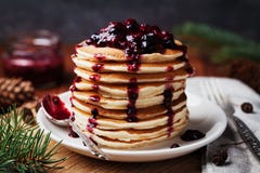 American pancakes or fritters served with strawberry and blueberry jam, delicious dessert for breakfast in winter