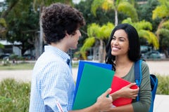 Amerikansk manlig student som talar med den indiska kvinnliga studenten royaltyfri fotografi Amerikansk manlig student som talar med den indiska kvinnliga studenten royaltyfri fotografi
