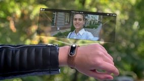 Ami d'appel de main de sportif de fille qui apparaît dans l'hologramme Montre intelligente futuriste et technologique Parc vert d clips vidéos Ami d'appel de main de sportif de fille qui apparaît dans l'hologramme Montre intelligente futuriste et technologique Parc vert d clips vidéos