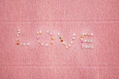 Ami la parola fatta degli zecchini, del luccichio e dei coriandoli su fondo rosa Fotografie Stock Ami la parola fatta degli zecchini, del luccichio e dei coriandoli su fondo rosa Fotografie Stock