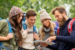 Amici o viaggiatori che fanno un'escursione con gli zainhi e la mappa fotografia stock libera da diritti Amici o viaggiatori che fanno un'escursione con gli zainhi e la mappa fotografia stock libera da diritti