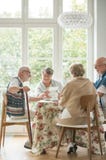 Amici senior che spendono insieme tempo bevendo tè e godendo delle foto fotografia stock Amici senior che spendono insieme tempo bevendo tè e godendo delle foto fotografia stock