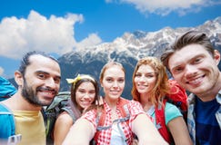 Amigos com a trouxa que toma o selfie sobre montanhas foto de stock Amigos com a trouxa que toma o selfie sobre montanhas foto de stock